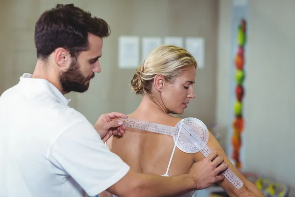 Erkek terapist kadın hastamı geri gonyometre ile ölçme — Stok fotoğraf