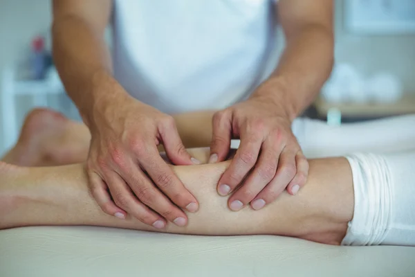 Fisioterapista che fa un massaggio alle gambe a una donna — Foto Stock