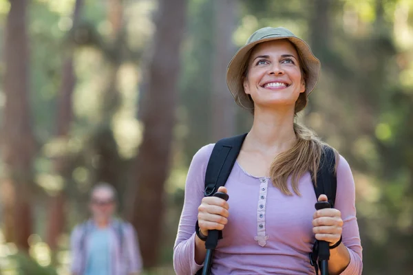 Lachende vrouw wandelaar wandelen met trekking Polen — Stockfoto