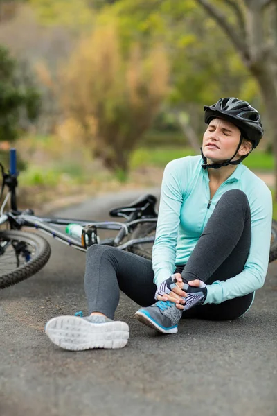 Ciclista con dolor sosteniendo su pierna lesionada —  Fotos de Stock