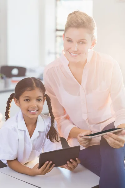 Leraar en schoolmeisje met behulp van digitale tablet in de klas — Stockfoto