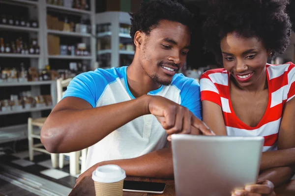 Pareja sonriente usando tableta digital en la cafetería — Foto de Stock