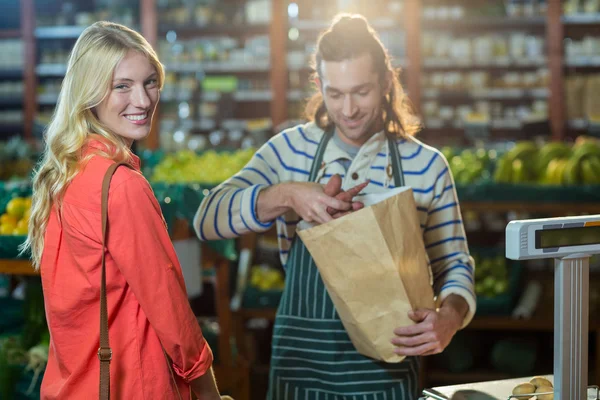 Man hjälpa kvinnan att välja grönsaker — Stockfoto