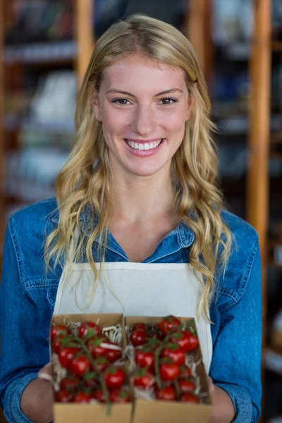 Sorrindo equipe feminina segurando caixa de tomate cereja — Fotografia de Stock