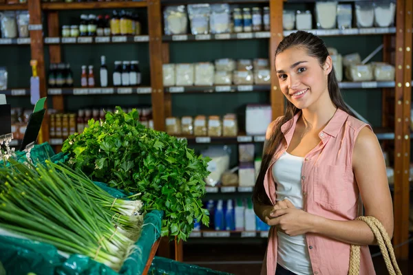 Wanita yang berdiri di samping daun bawang dan herbal — Stok Foto