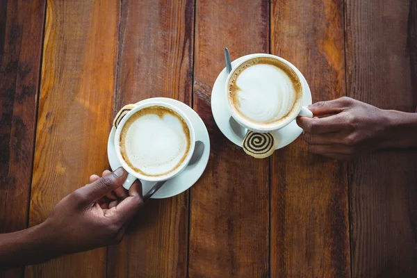 Pari käsi tilalla kuppi kahvia — kuvapankkivalokuva