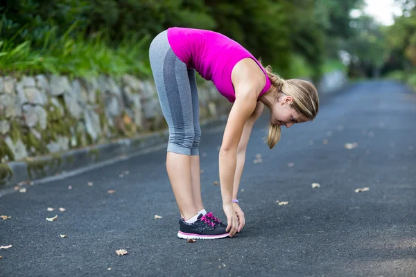 Mujer ejercitándose en el camino abierto — Foto de Stock