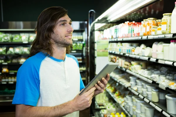 Mann hält beim Einkaufen digitales Tablet in der Hand — Stockfoto