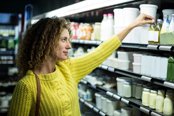 Женщина покупает бутылку масла — стоковое фото