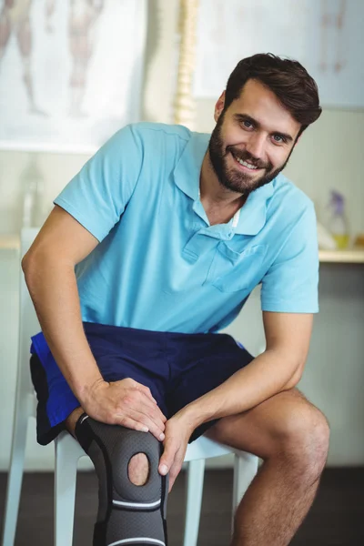 Portrait of smiling man with knee injury — Stock Photo, Image