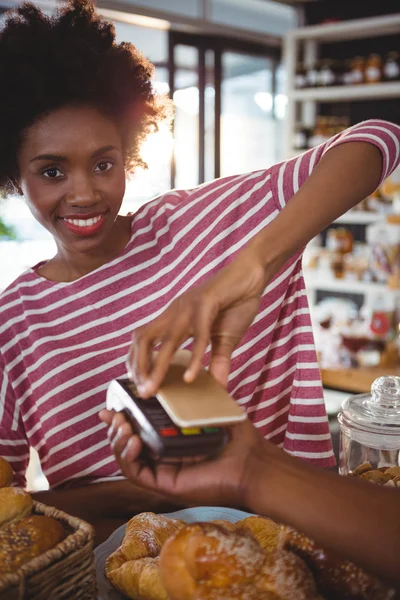 Sorrindo mulher pagar conta através do smartphone — Fotografia de Stock