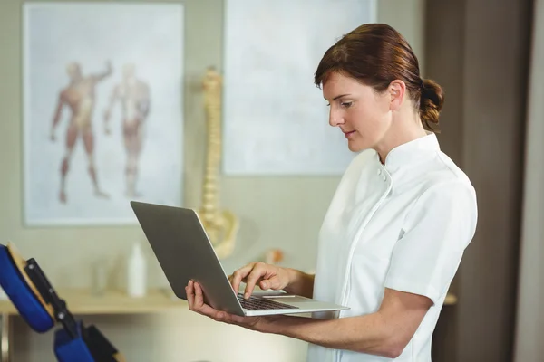 Physiotherapist using a laptop — Stock Photo, Image