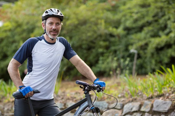 Hombre de pie con bicicleta de montaña en el camino —  Fotos de Stock