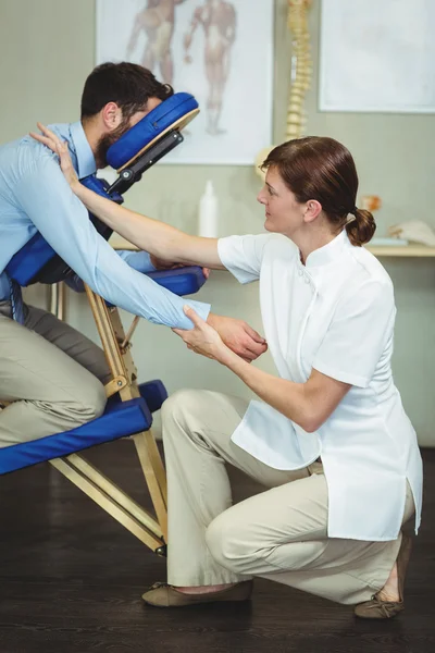 Fisioterapeuta dando masaje en el brazo a un paciente — Foto de Stock