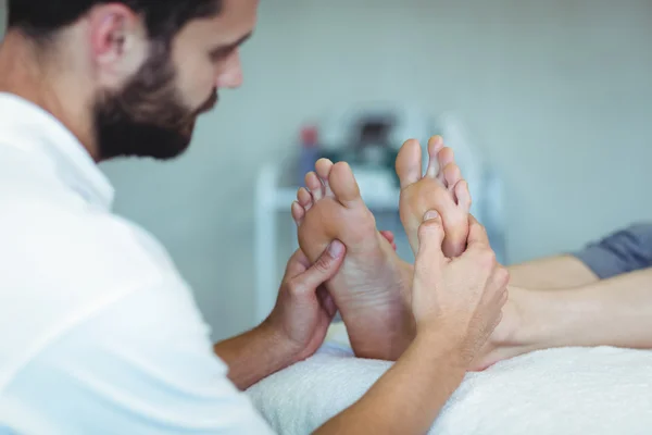 Fisioterapeuta dando massagem nos pés para uma mulher — Fotografia de Stock