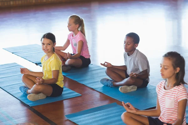 Bambini della scuola che meditano durante la lezione di yoga — Foto Stock