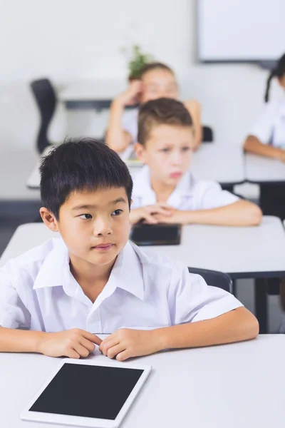 Schooljongen zit in de klas — Stockfoto