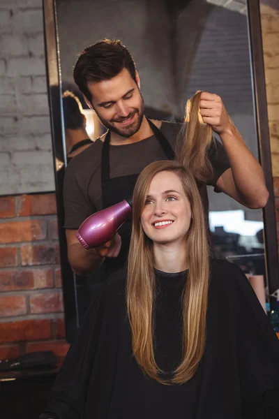 Mulher bonita recebendo seu cabelo seco — Fotografia de Stock