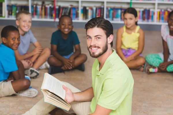 Profesor enseñando a los niños en la biblioteca — Foto de Stock