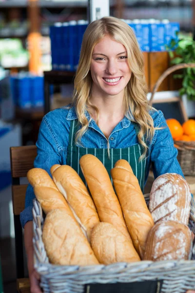 Baget ekmek sepeti tutan gülümseyen kadın — Stok fotoğraf