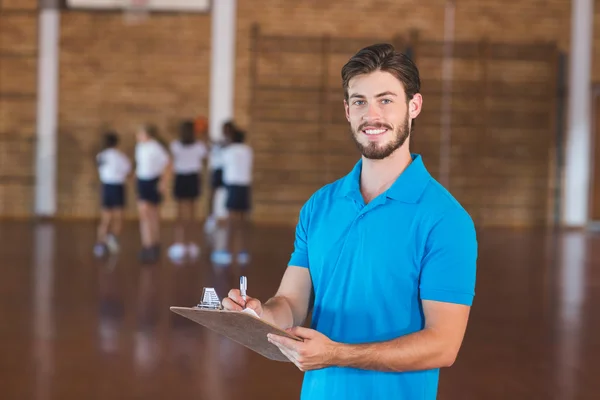 Porträt eines Sportlehrers, der auf Klemmbrett schreibt — Stockfoto