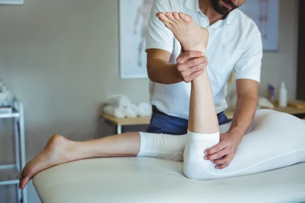 Physiotherapeutin gibt einer Frau eine Beinmassage — Stockfoto