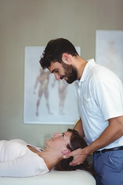 Fisioterapeuta dando masaje en la cabeza a una mujer —  Fotos de Stock