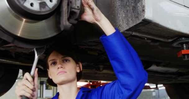 Женщина-механик осматривает колесо автомобиля — стоковое видео