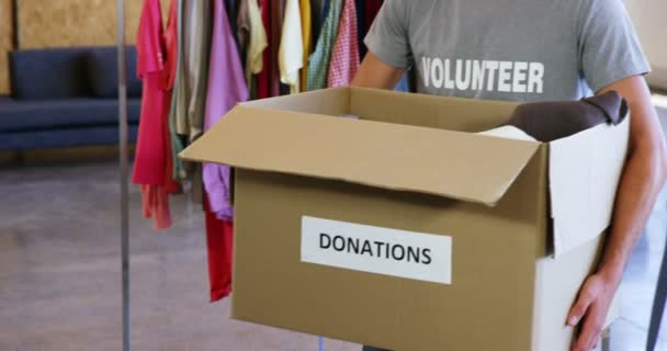 Voluntário segurando caixa de doação de roupas — Vídeo de Stock