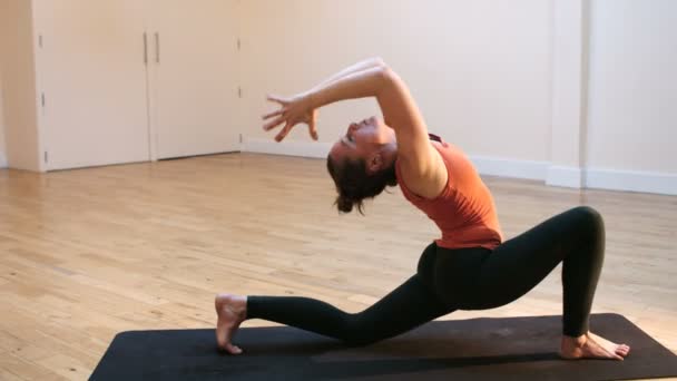 Donna che fa esercizio di stretching sul tappeto — Video Stock