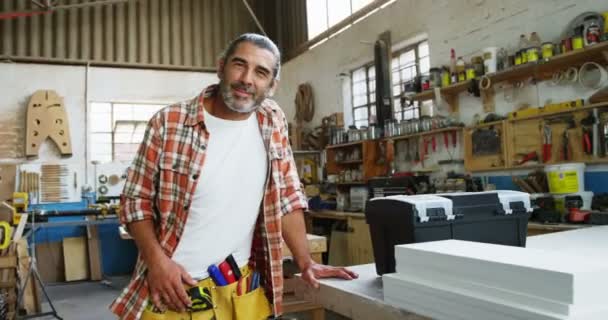 Carpintero en taller mirando a la cámara — Vídeos de Stock