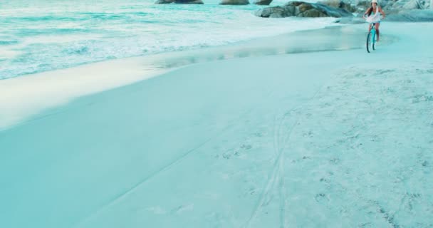 Woman cycling on beach — Stock Video