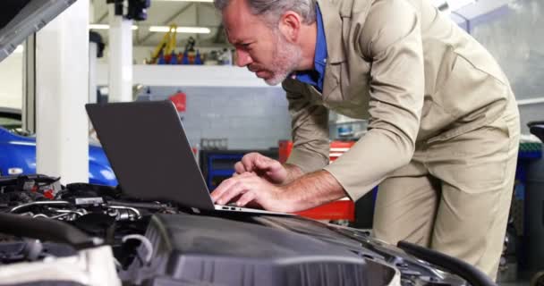 Mécanicien utilisant un ordinateur portable lors de l'entretien du moteur — Video