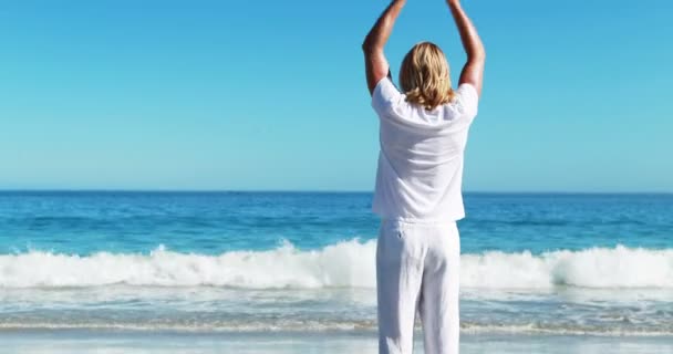 Mann macht Yoga am Strand — Stockvideo
