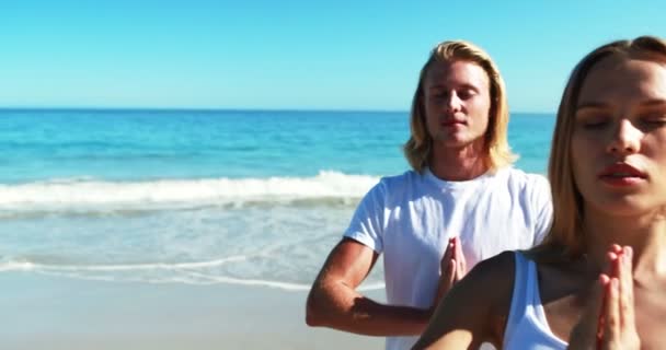 Pareja realizando yoga en la playa — Vídeos de Stock