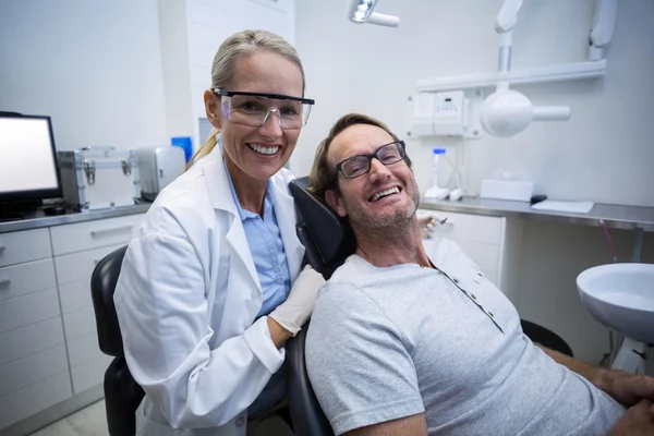 Kadın diş hekimi ve gülümseyen erkek hasta — Stok fotoğraf