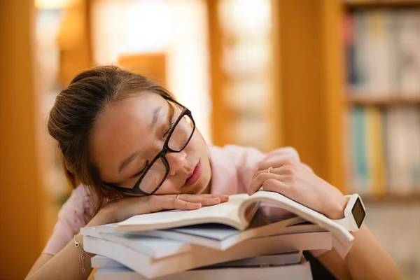 Jonge vrouw slapen in bibliotheek — Stockfoto