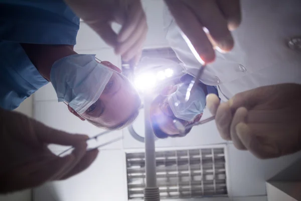 Dentista em máscara cirúrgica segurando ferramentas dentárias — Fotografia de Stock