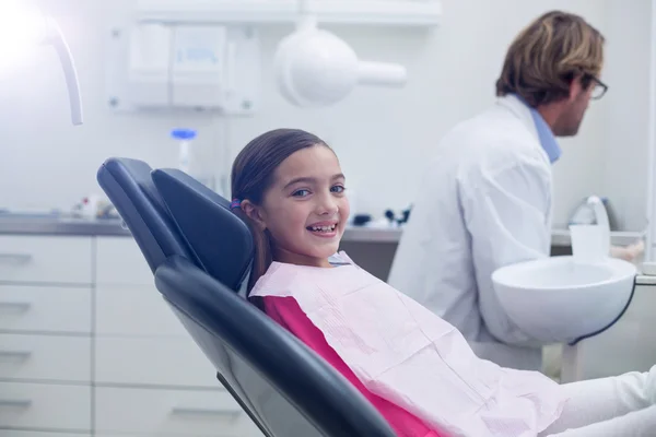 微笑着年轻患者坐在牙医的椅子上 — 图库照片