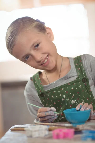 Girl painting on bowl in pottery workshop — Stock Photo, Image