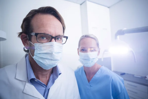 Porträtt av tandsköterska och tandläkare bär kirurgisk mask — Stockfoto