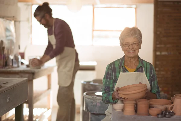 Töpferin hält Töpferei in der Hand — Stockfoto