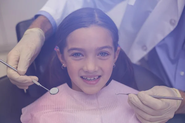 Dentista examinando a un paciente joven con herramientas — Foto de Stock