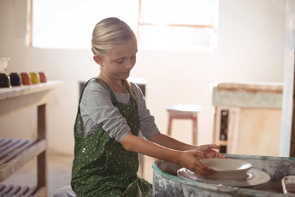 Attentive girl making pot — Stock Photo, Image