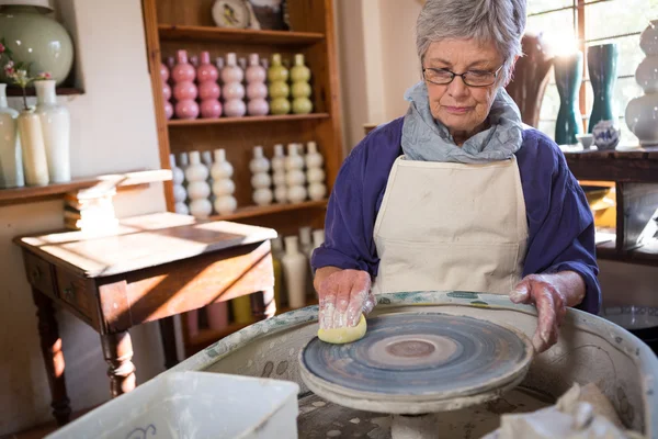 Oleiro feminino limpeza roda de cerâmica — Fotografia de Stock