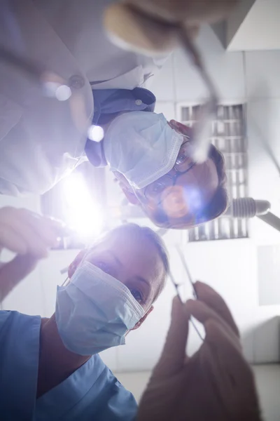 Dentist in surgical mask holding dental tools — Stock Photo, Image