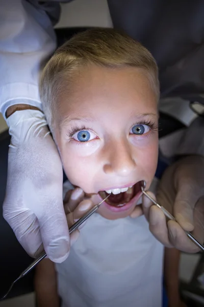 Dentista examinando um paciente jovem com ferramentas — Fotografia de Stock