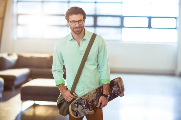 Homme dirigeant d'entreprise debout avec skateboard — Photo