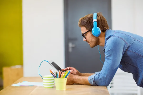 Business executive listening to music on tablet — Stock Photo, Image