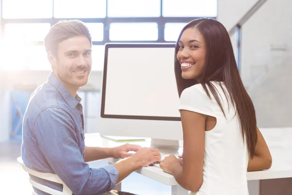 Empresaria con compañero de trabajo trabajando en la computadora —  Fotos de Stock